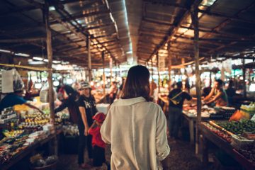 Woman walks through a fish market on the streets while traveling through Asia.