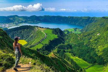 Hiker overlooking the beautiful landscape of Sete Cidades lake on Sao Miguel Island, in the Azores. The Azores are a top spring break destination for 2025.