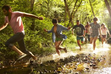 Group-of-friends-running-through-stream