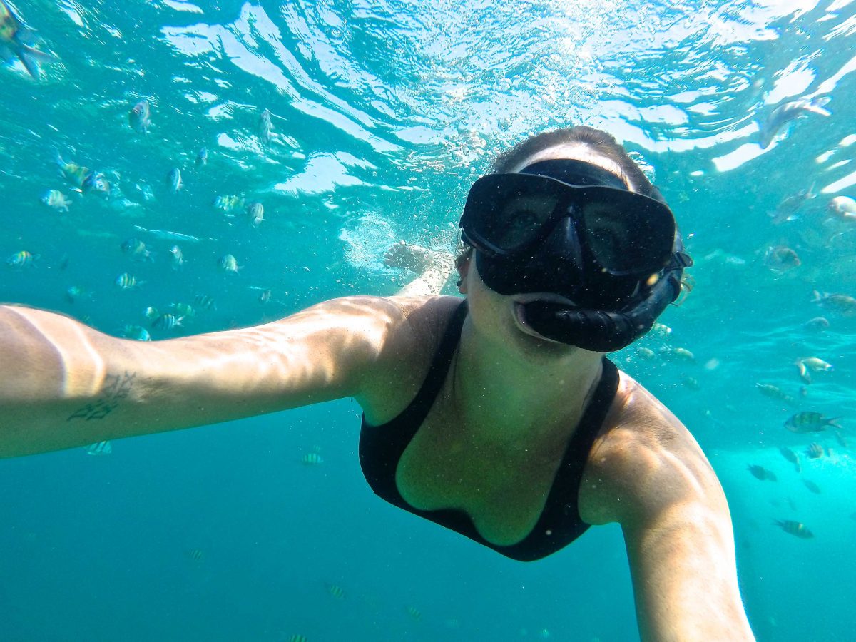 Girl snorkling in the ocean waters while island hopping in Thailand.