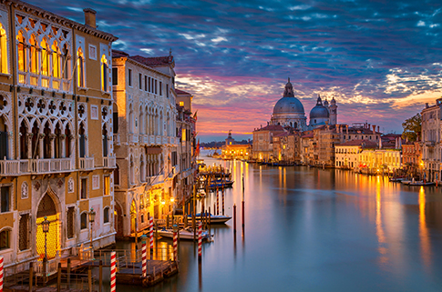 Italian cityscape with water at dusk.