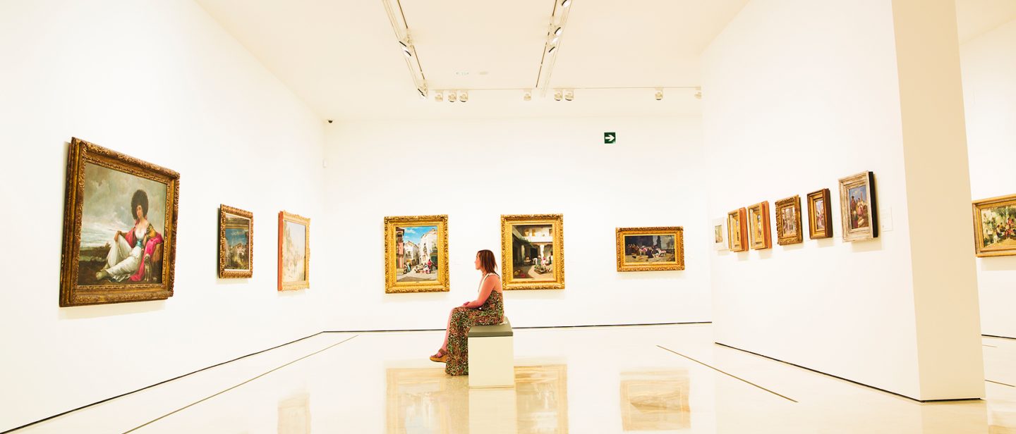 Woman sitting in room in the Carmen Thyssen Museum in Malaga, Spain.