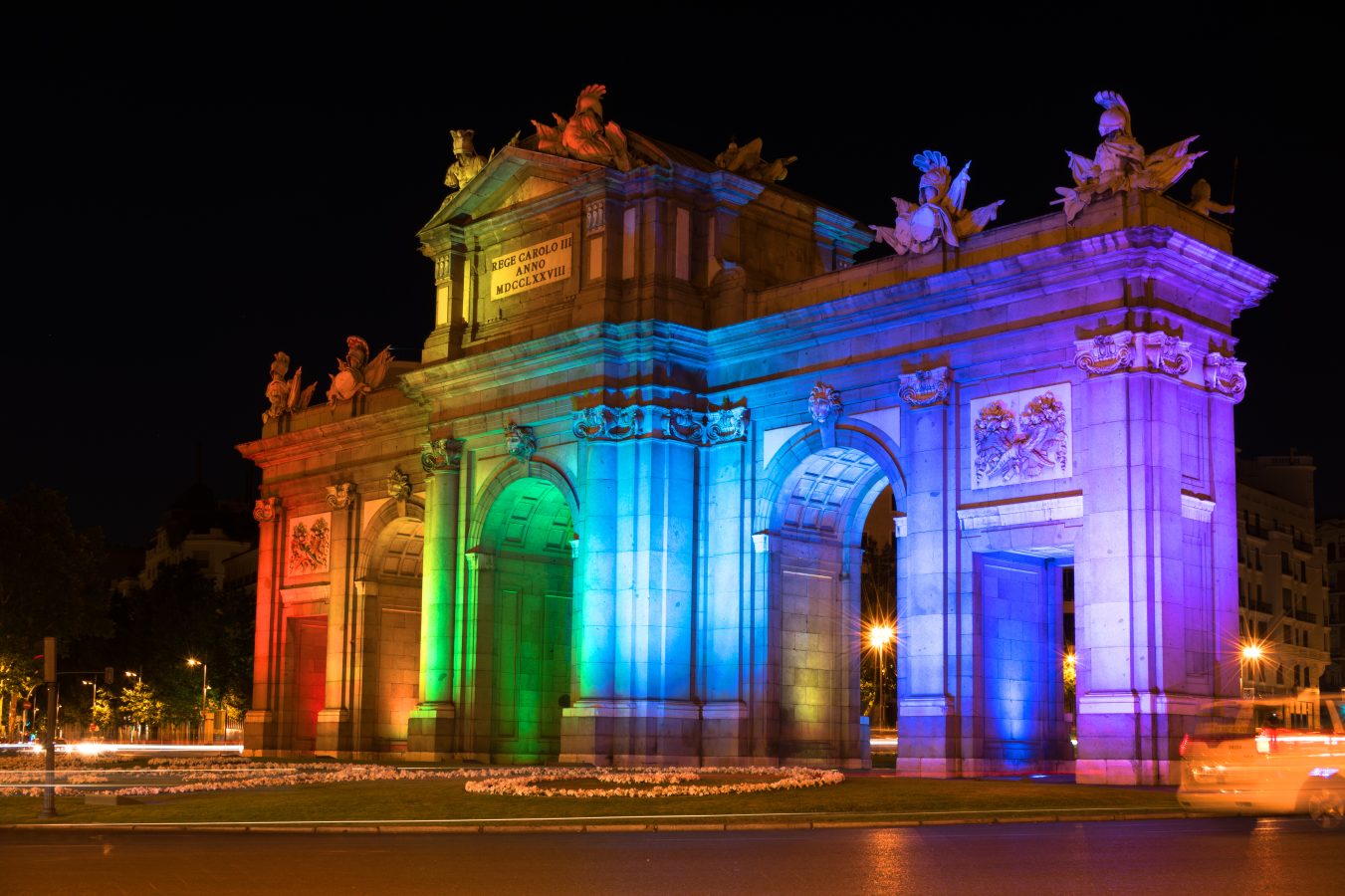 Alcala Gate in Madrid lit up with rainbow lights, celebrating World Pride Week.