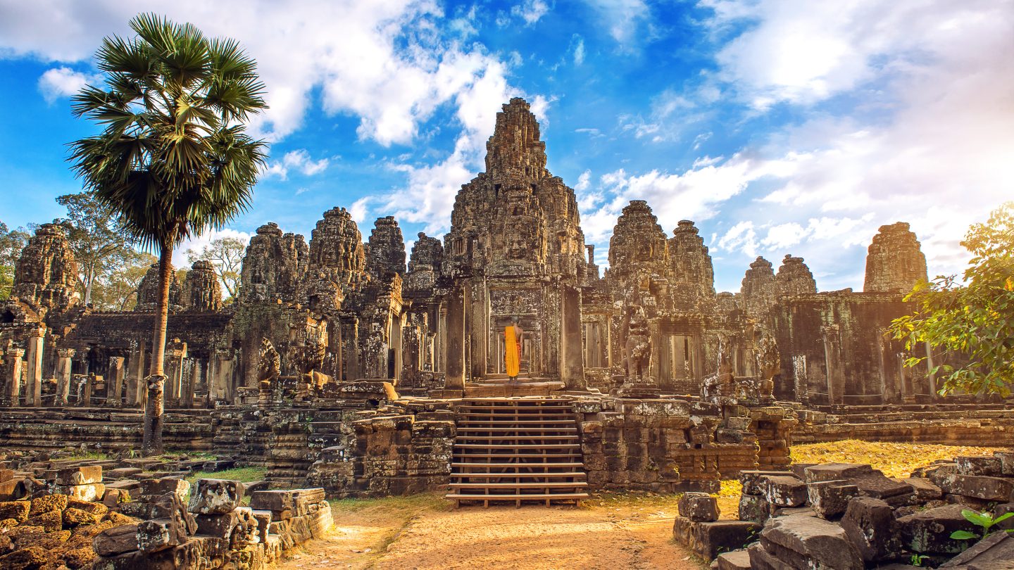 Ancient stone faces at sunset of Bayon temple, Angkor Wat, Siam Reap, in Cambodia. The country is a very affordable student travel destination from India.