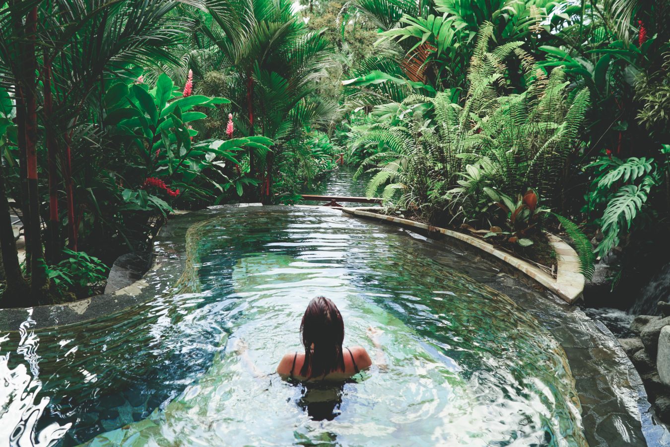 Traveler soaking in a natural hot spring, relaxing and taking care of themself during their gap year travel.