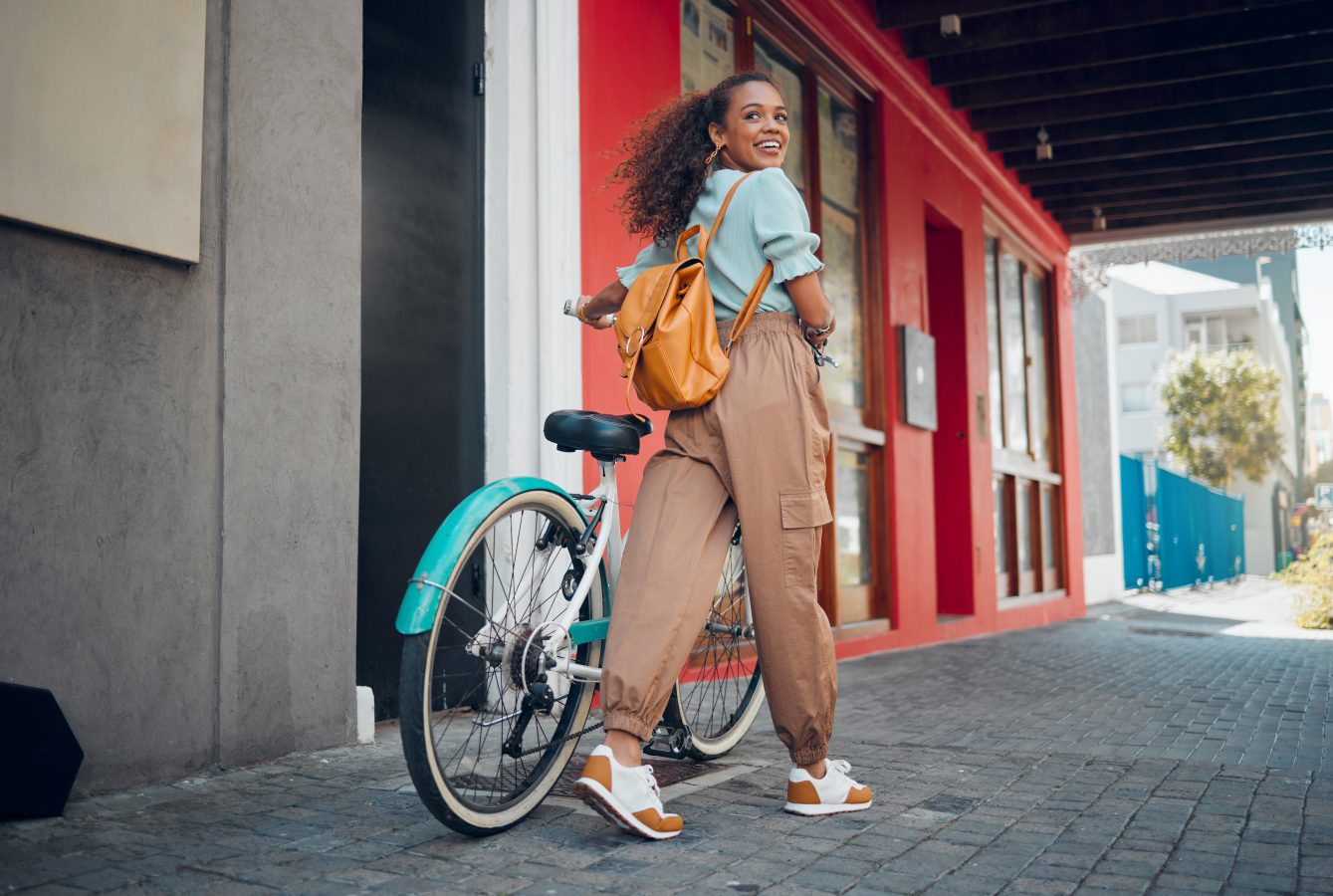 Girl with a bicycle for travel to university to reduce carbon footprint outdoors.