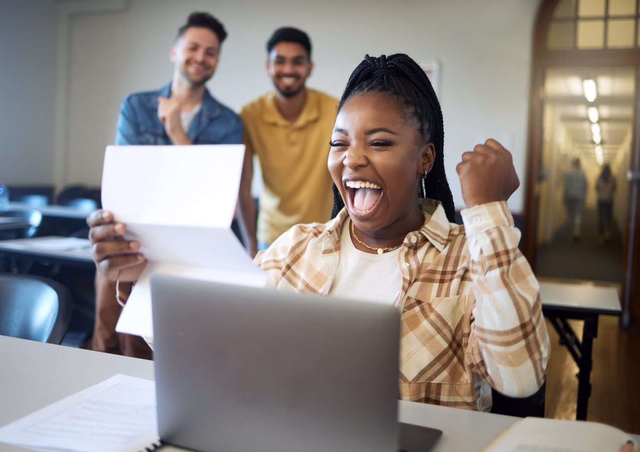 University student excitedly reading her acceptance letter after having applied for travel scholarships and grants.