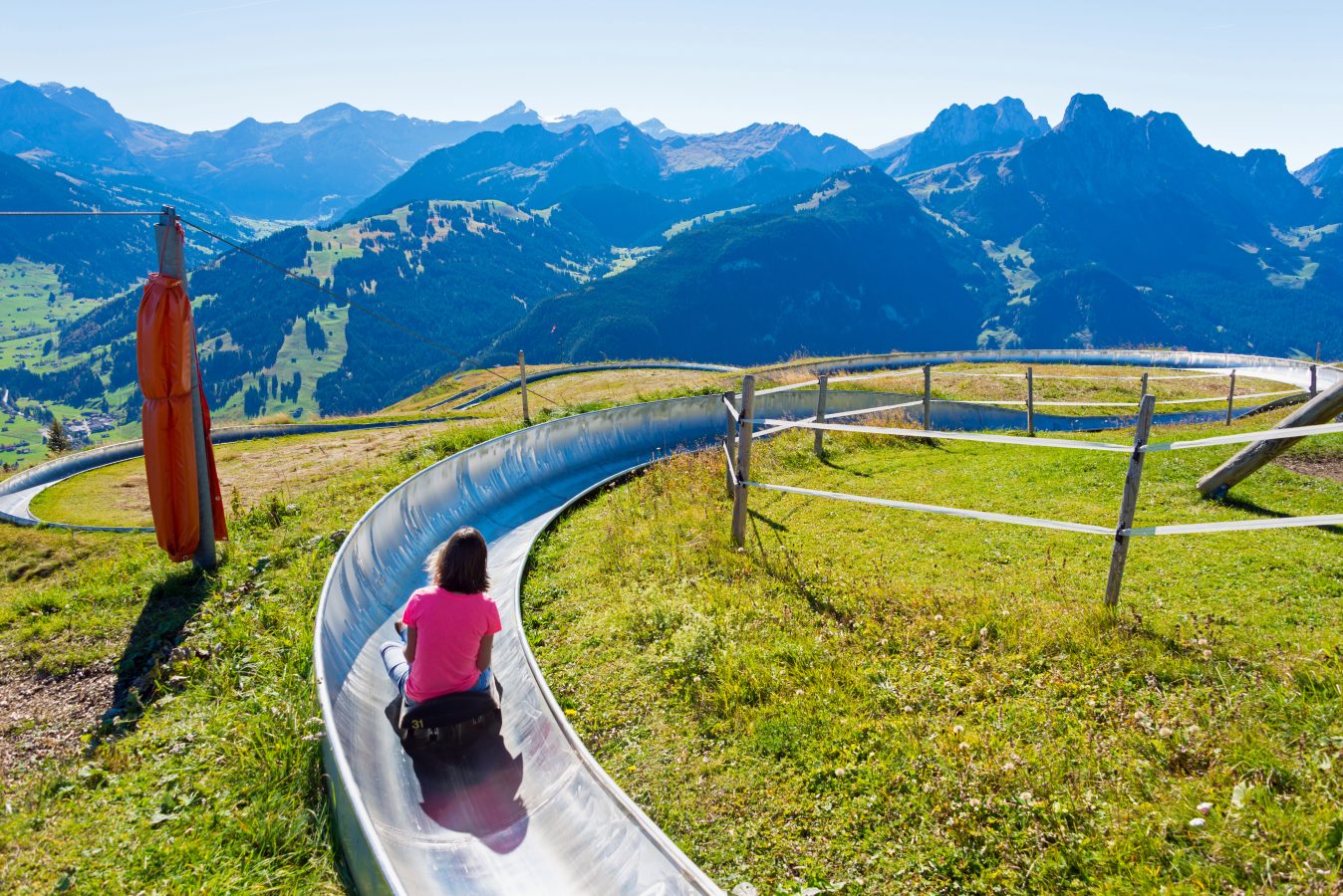 Toboggan riding down a grassy mountain in Switzerland.