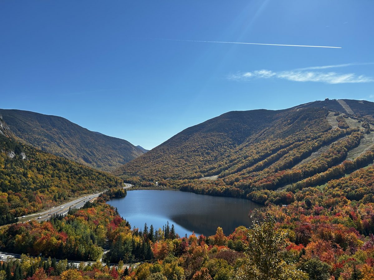 Artist's Bluff in the White Mountains of New Hampshire during fall foliage on a clear, blue sky day. It's a great destination to get photos for your fall instagram post and use our captions.