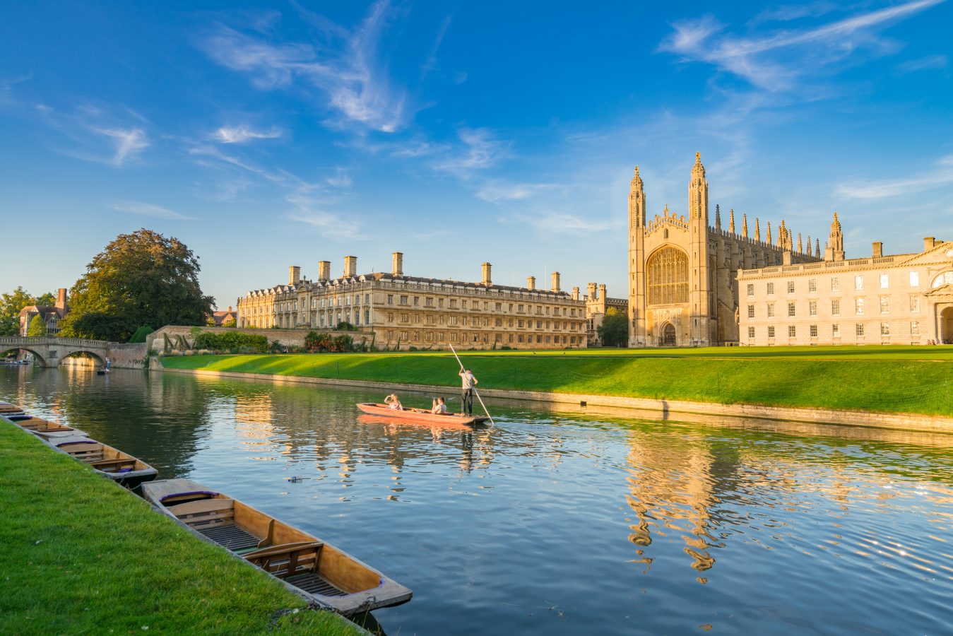 Beautiful view of college in Cambridge with people punting on river.